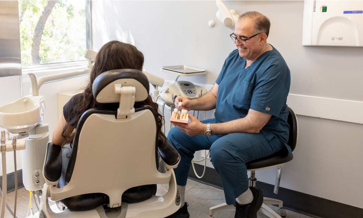 Dr. Abdul Wehbe showing a patient how dental implants work
