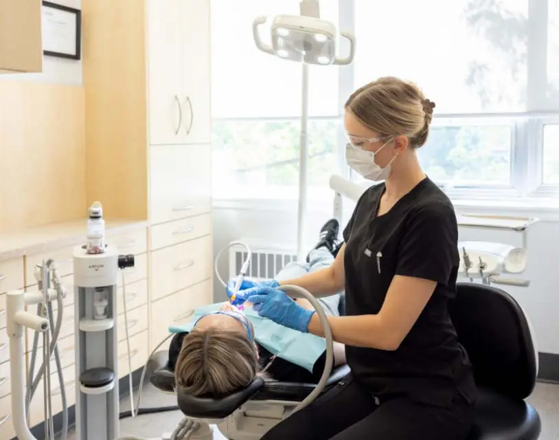 Dental hygienist using airflow technology on a preventive dentistry patient