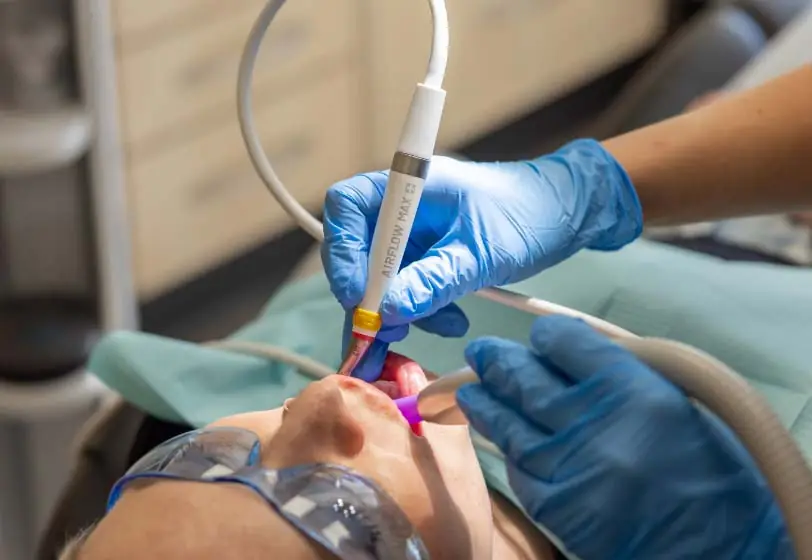 Female patient receiving airflow therapy during a preventive dentistry appointment